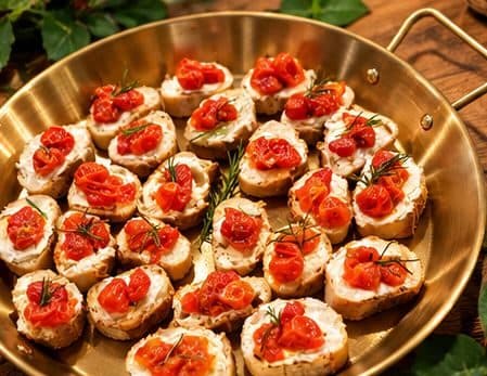 Bruschettas com tomate confit e alecrim em travessa dourada